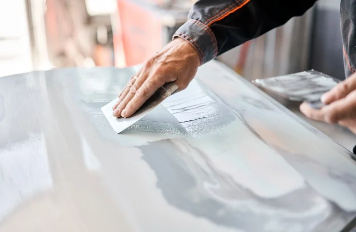 Person spachtelt Auto